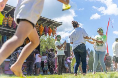 Tauranga Yeni Zelanda - 4 Mart 2023; Somene 'nin Holi Colour Splash festivalinde koşması üzerine kalabalık içinde renkli pudra dansı yapan kadınlar.