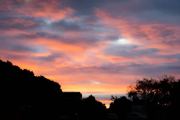 stock image Sunset and cloud colours in sky over silhouette landscape