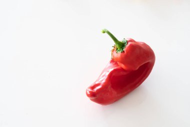 Beyaz arkaplanda parlak kırmızı çirkin şekilsiz kapsicum.