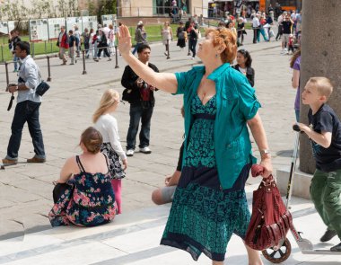 Pisa İtalya - 23 Nisan 2011; Kentsel caddedeki insanlar yeşil saçlı kadınların kollarını kaldırması