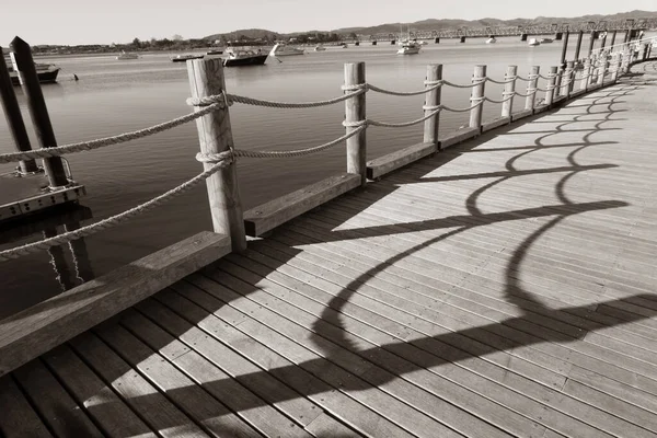 ロープや柱の影のパターンは タウランガ市のウォーターフロントに沿って 港と青空の背景と — ストック写真