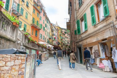 Riomaggiore İtalya - 24 Nisan 2011; Turistler ve yüksek apartman duvarları ile tipik dar şehir caddesi boyunca görünüm.