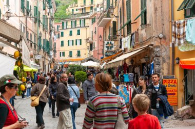 Cinque Terre İtalya - 25 Nisan 2011; Küçük Cinque Terre yamaç köyündeki kalabalık tipik İtalyan caddesinde halk ve turistler