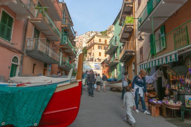 Manarola İtalya - 25 Nisan 2011; Manarola tuhaf gölgeli cadde, turistlerin gezdiği binalarla çevrili kırmızı botlar