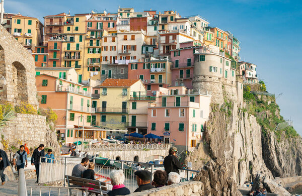 Manarola Italy - April 25 2011; View of homes of Manarola ancient fishing village build on rock cliff face above Mediterranean sea.