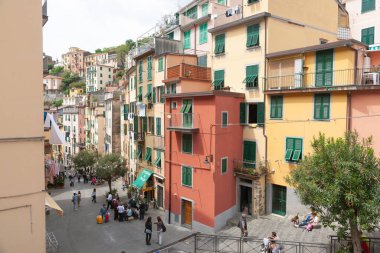 Riomaggiore İtalya - 25 Nisan 2011; Cinque Terre sokağının aşağısında. Kafeler, dükkanlar ve teraslarla dolu bir balıkçı köyü.