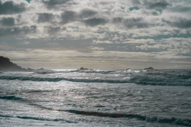 Fırtınalı deniz ve Maunganui Dağı 'nda sörf. Tauranga Yeni Zelanda. Düşük kroma etkisi..