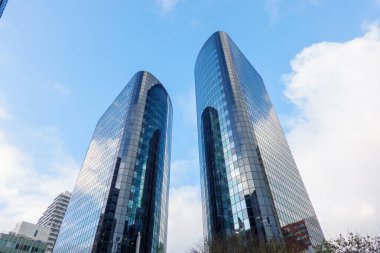 İki modern büyük şehrin tepesinde yükselen cam perdeler binalar ve yansımalar.