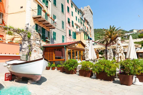 Portovenere, İtalya 'da kafe ve renkli Ligurian evlerinin kaldırımları üzerindeki kayıklar.