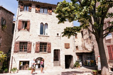 Saint Paul de Vence, Provence, Fransa - 2 Mayıs 2011; Eski taş binalarla çevrili iki turist