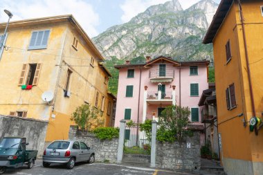 Cima, İtalya - 5 Mayıs 2011; Lugano Gölü 'nün etrafındaki dağ zirveleri ev ve binaların arkasında yükseliyor.