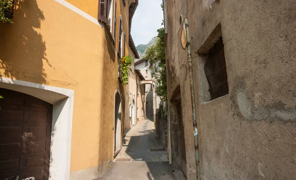 İtalya 'nın Cima kasabasında Lugano Gölü kıyısındaki binalar arasında dar bir yol ve yol var..