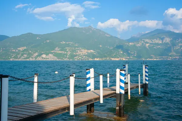 Пирс Белыми Голубыми Полюсами Озере Комо Горном Фоне Menaggio Италия — стоковое фото
