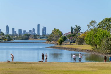 Gold Coast Avustralya - 17 Eylül 2023: güneşli bir öğleden sonra şehir parkı göletinin oradaki insanlar