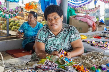 Nadi Fiji - 15 Eylül 2023; Fiji 'de çiftçiler ve el sanatları pazarında turistler için el işi yapan ve satan Fijili kadınlar.