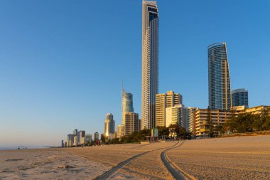 Sörfçüler Paradise Avustralya - 23 Eylül 2023; Surfers Paradise plajı ve gökyüzüne doğru uzanan binalarla gökyüzü çizgisi. Kumda iz çizgilerinin ötesinde.