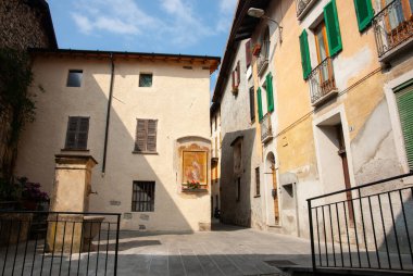 Cima İtalya 5 Mayıs 2011; Kapalı pencereli binalarla çevrili asfalt avlu.