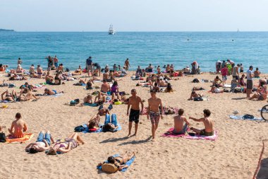 Cannes, French Riviera - Mayıs 2011; Fransız Riviera plajında güneşlenenler arasında iki genç adam yürüyor