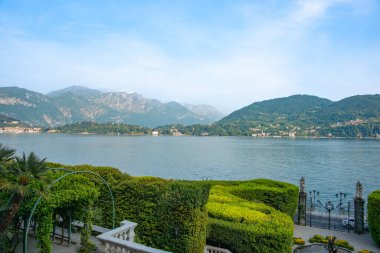 Como Gölü 'nden diğer taraftaki Menaggio kasabasına. Dağ arkaplanı ve manzara bahçesiyle.