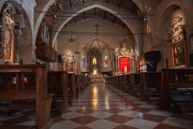 Sermione İtalya - 9 Mayıs 2011; Duvarların etrafında loş ışık, simgeler ve sanatla katolik kilisenin içi.