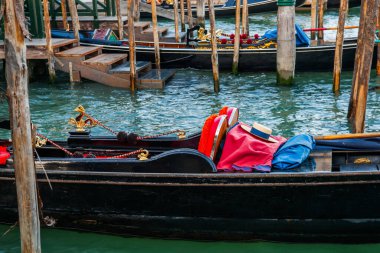 Panama şapkası kırmızı halıda, siyah gondolda, iskelede, karakteristik Venedik görüntüsünde.