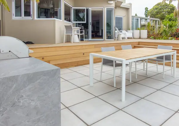 New outdoor deck and entertaining area design in wood and tiles with table and chairs.