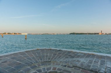 View from Island of Lido to Venice under clear blue sky  as cruise ship arrives Italy for scenic or background use.