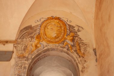 Gubbio Umbria, İtalya - 12 Mayıs 2011; İtalyan kilisesinde üzerinde Latince ifadeler bulunan plaketi tutan çıplak çocukların geleneksel freski.