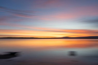 Arka planda günbatımı kasıtlı kamera hareketi sabah açık mavi saatte yumuşak renkleri etkiler.