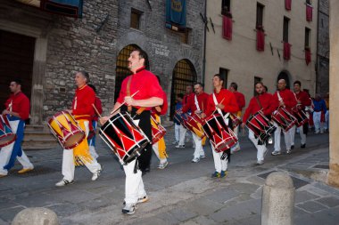 Gubbio Umbria, İtalya-15 Mayıs 2011; Yıllık Festa dei Ceri kutlamaları sırasında sokakta çalan kırmızı üniformalı davulcular