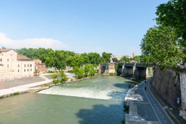 Tiber Nehri üzerindeki eski taş köprü. Yol ve binalardan akan sular..