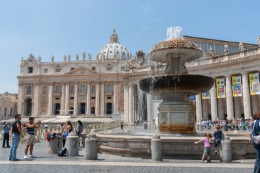 Roma İtalya 21 Mayıs 2011; St. Peter Meydanı Çeşmesi. Vatikan 'da. Bazilika ve turistlerle.