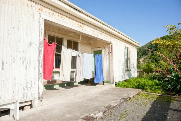 stock image Old farm workers living quarters with towels hanging in veranda drying in rural New Zealand.