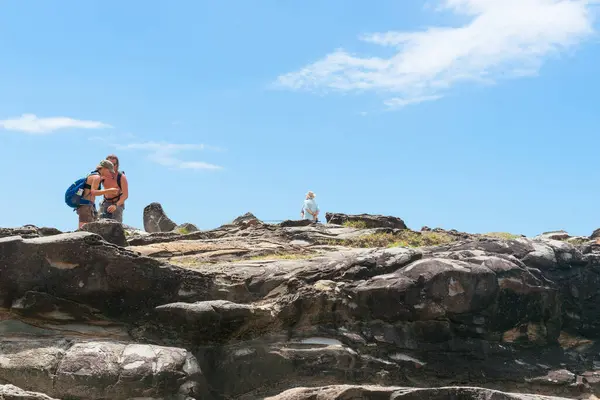 stock image Yamba Australia - February 10 2012; Tourists exploring the rock structure under blue summer sky.