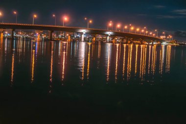 Tauranga Liman Köprüsü gece aydınlandı. Işıklar suya yansıdı..