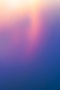 Sakin su. Güneş ufkun altına kayarken yüzey mavi üzerine parlak pembe bir renk alarak soyut bir zemin oluşturuyor..