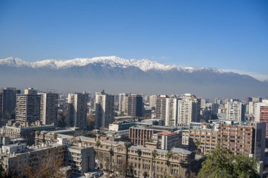 Şili 'nin başkenti Santiago' nun uzak karlı And Dağları şehir siluetinin ötesinde..
