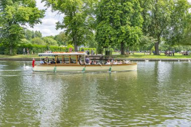 Stratford Upon Avon - Birleşik Krallık; 29 Temmuz 2024; Turistler ve yerliler Avon Nehri 'nin yayan geçidinde, teknelerde ve köprüde eğleniyorlar. 2024; Yolcular yaz günü Avon Nehri 'nde Neşeli Dul teknesinde seyahet eder.