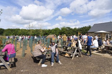 The Cotswolds United Kingdom - July 26 2024; Crowd dining outdoors and lining up at Diddly Squat the subject of Jeremy Clarkson TV series. clipart