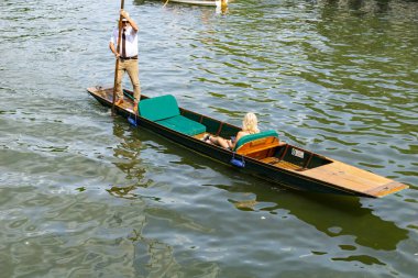 Stratford Upon Avon - Birleşik Krallık; 29 Temmuz 2024; Sarı saçlı kadın güneşli bir günde Daphne adlı nehir teknesinde sırıkla geziyor..