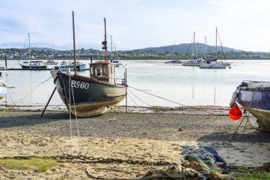 Conwy Wales - July 30 2024; Boat on beach on side of Conwy River. clipart