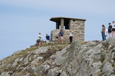 Anglesea Wales  Old stone coastguard lookout overlooking South Stack lighthouse at Anglesea clipart