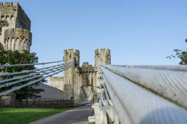 Suspension cables of bridge and path provide leading lines of bridge to Conwy Castle entry in portrait aspect ratio. clipart