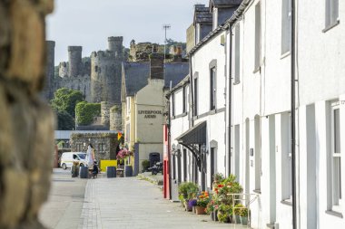 Conwy Wales - 30 Temmuz 2024; Quay 'den Kale' ye giden kemer kapısından aşağı kapı boyunca beyaz bina cepheleri.