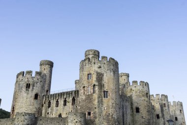 Mavi gökyüzü arkaplanına karşı Conwy Kalesi 'nin siperleri, kuleleri ve kuleleri.