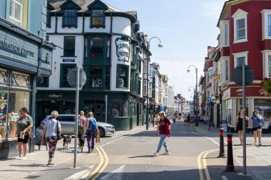 Aberystwyth Birleşik Krallık - 2 Ağustos 2024; Welsh kentsel caddesinde yürüyen yaşlı kadın.