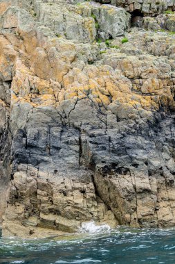 Farklı kaya katmanları Pembroke Galler 'deki Ramsay Adası' nın jeolojik tarihini gösteriyor..
