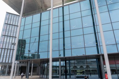 Cardiff Wales - 7 Ağustos 2024; Pencerelere yansıyan inşaat vinçleri ile sokaktan cam perdeli modern ticari mimari.