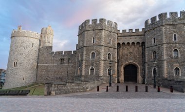 Outside walls and architectural features of Windsor Castle in morning light from streets below. clipart