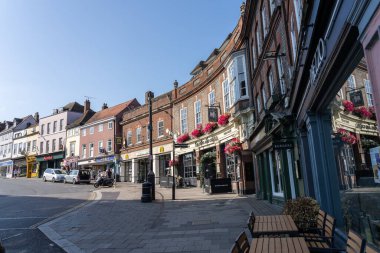 Windsor Birleşik Krallık - 12 Ağustos 2024; Windsor Şatosu 'na yaklaşan alt köşe, güneş doğarken ve yol ve cephelerde gölgeler bırakırken dükkan, kafe restoranları ve barlarla dolu..